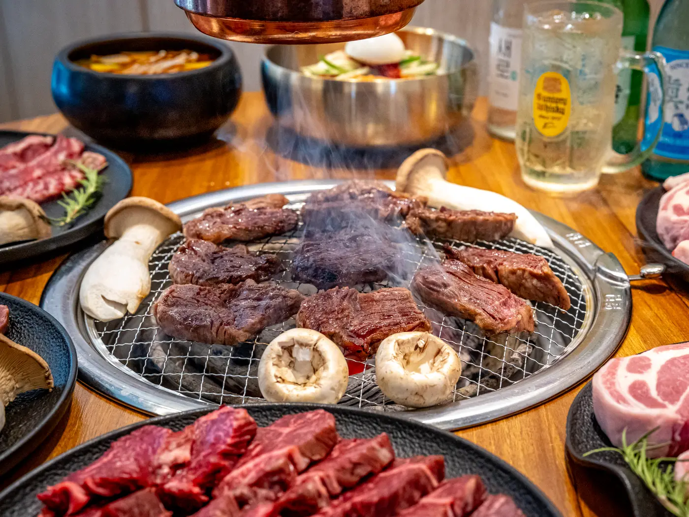우주집 홍대본점 테이블 전경 — 불판과 곁들임, 음료